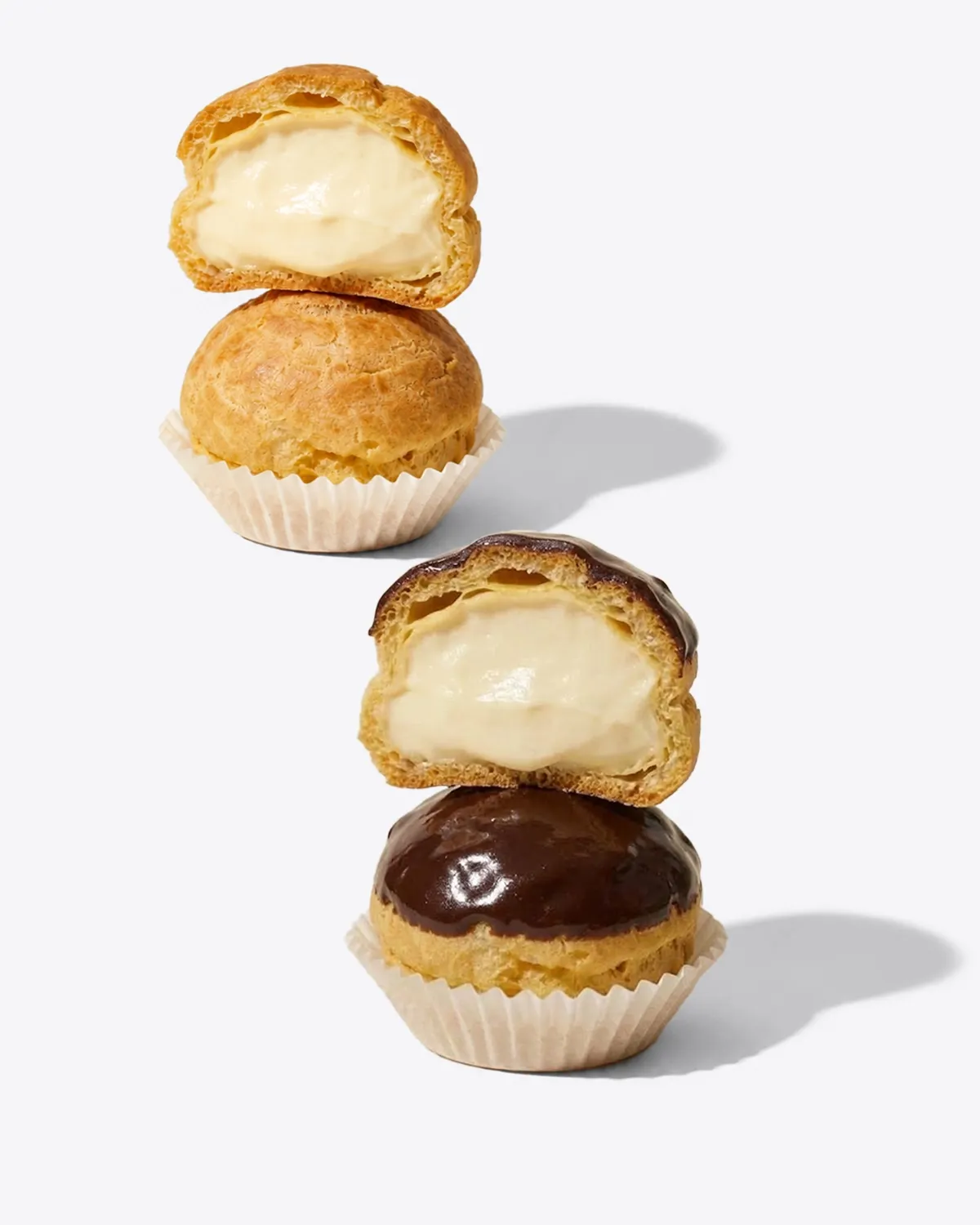 Soes original dan soes topping cokelat, dibelah memperlihatkan isiannya